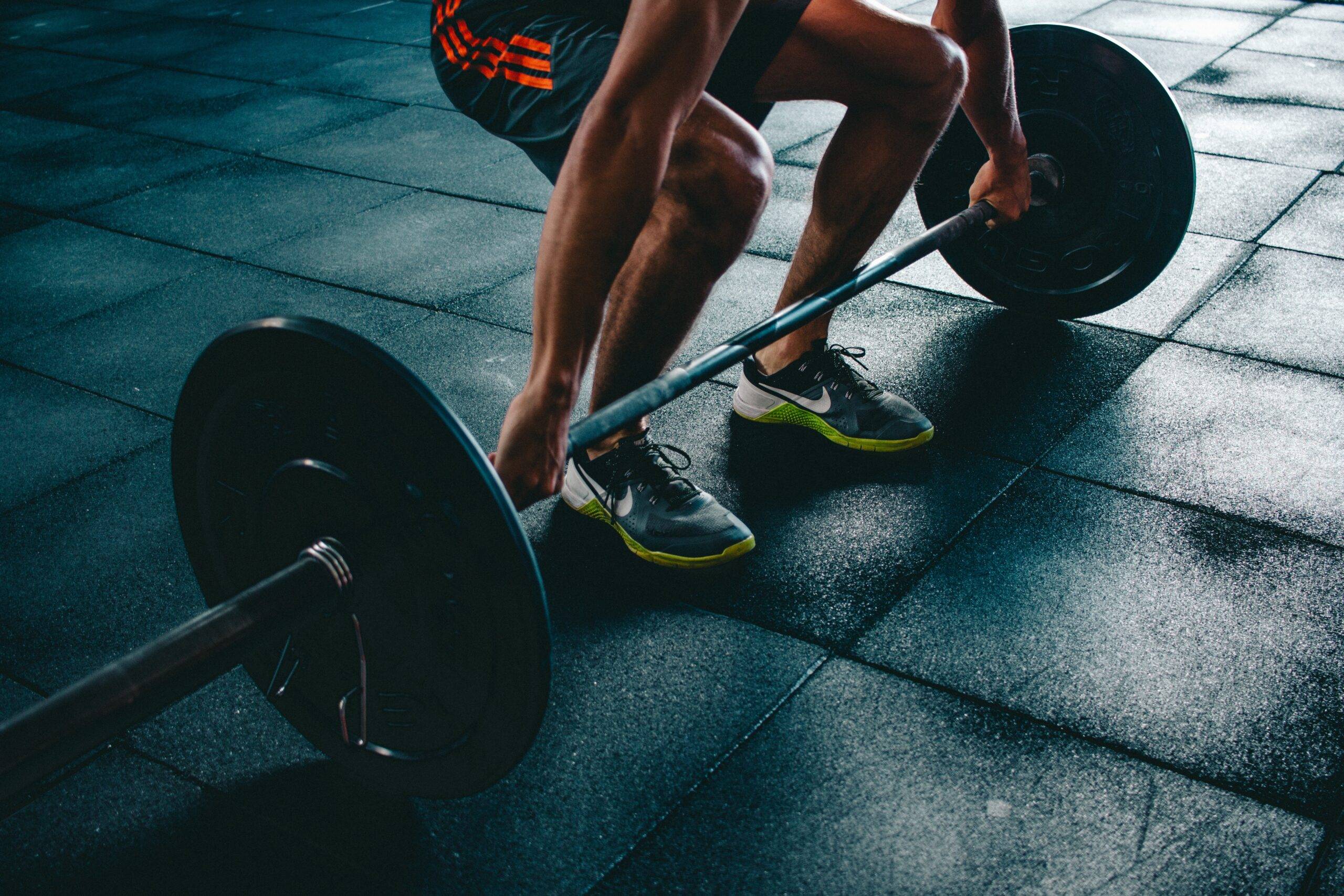 Aguy lifting weights in gym showing mental stength